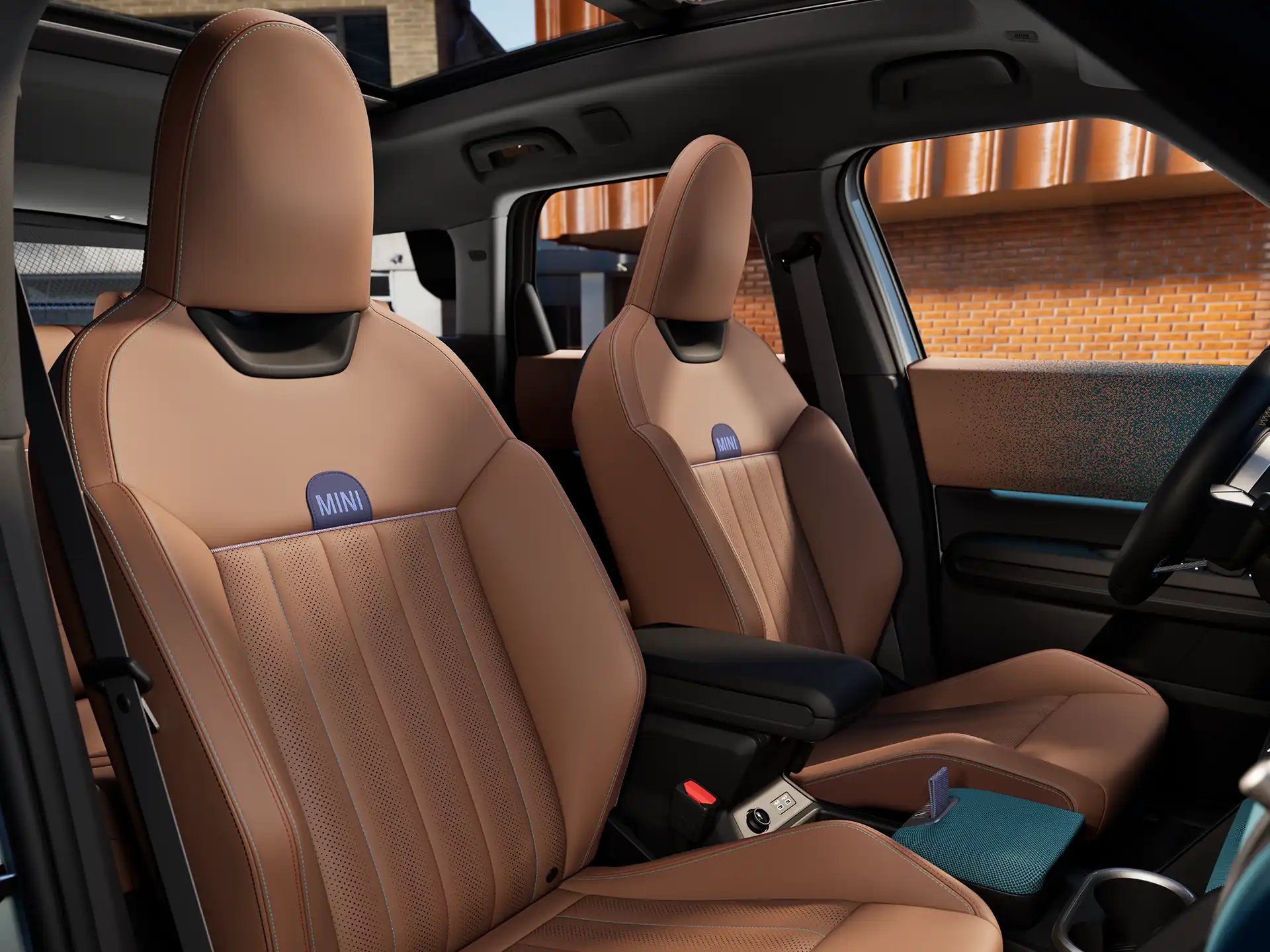 Interior perspective of the MINI Countryman is showing the dashboard, steering wheel, round display, panorama glassroof  and back of the frontseats.
