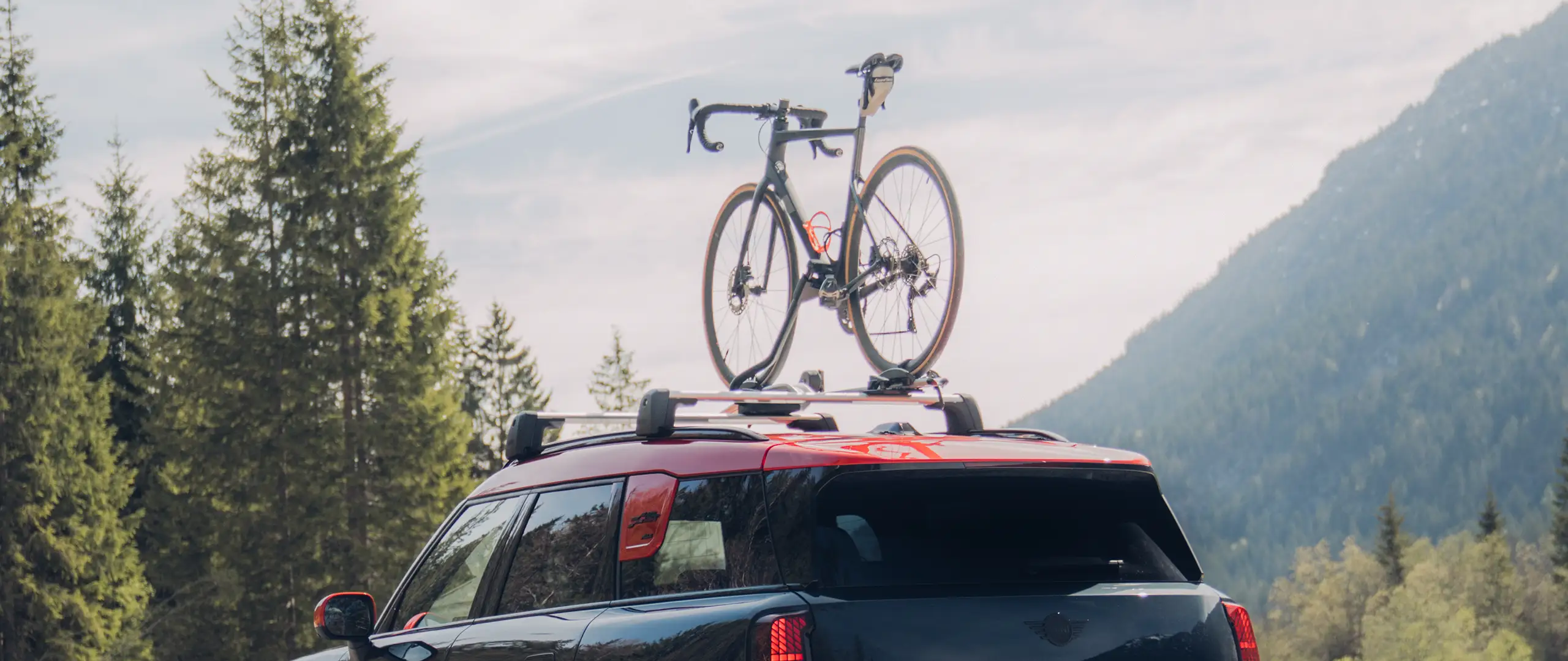 MINI Countryman Cooper in Black with MINI Roof Rack and MINI Roof Cycle Carrier with one bike – rear-side view
