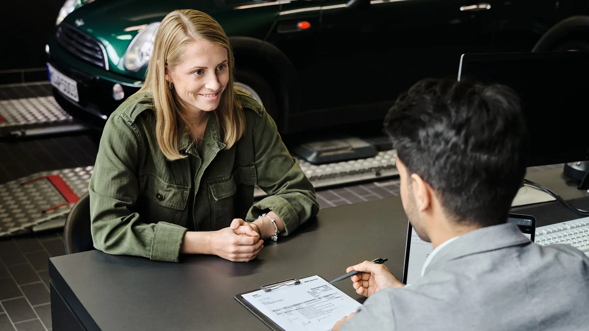 MINI Centre with consultant advising customer about her service options, both sitting at a table.